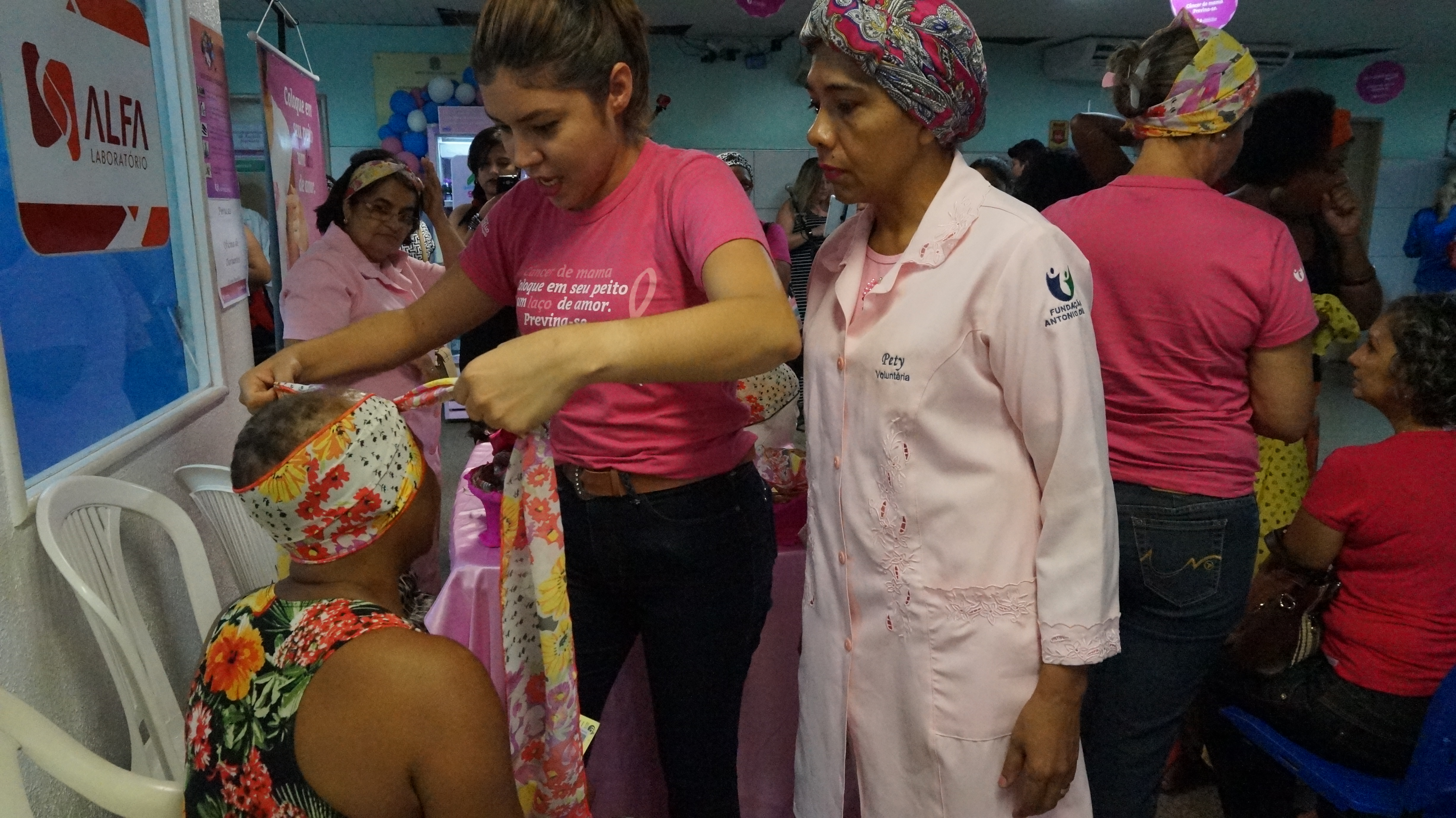 Voluntárias fazem turbante em paciente